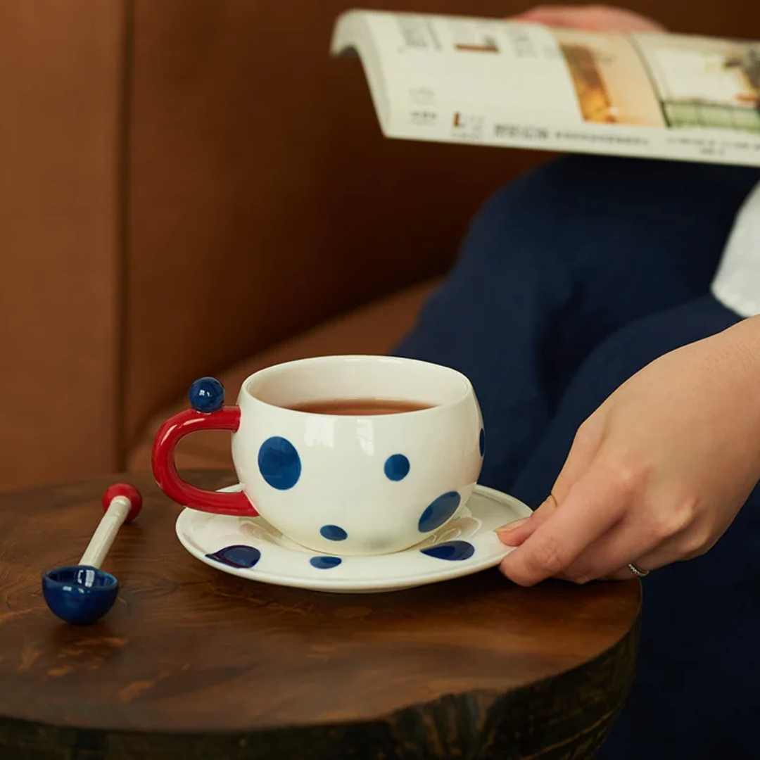 White mug with navy blue dots with spoon