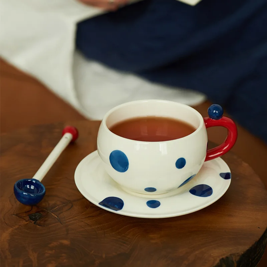 White mug with navy blue dots with spoon