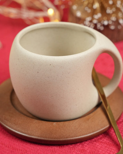 Ceramic coffee cup with spoon and wooden coaster