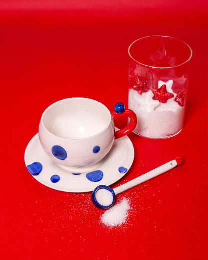 White mug with navy blue dots with spoon