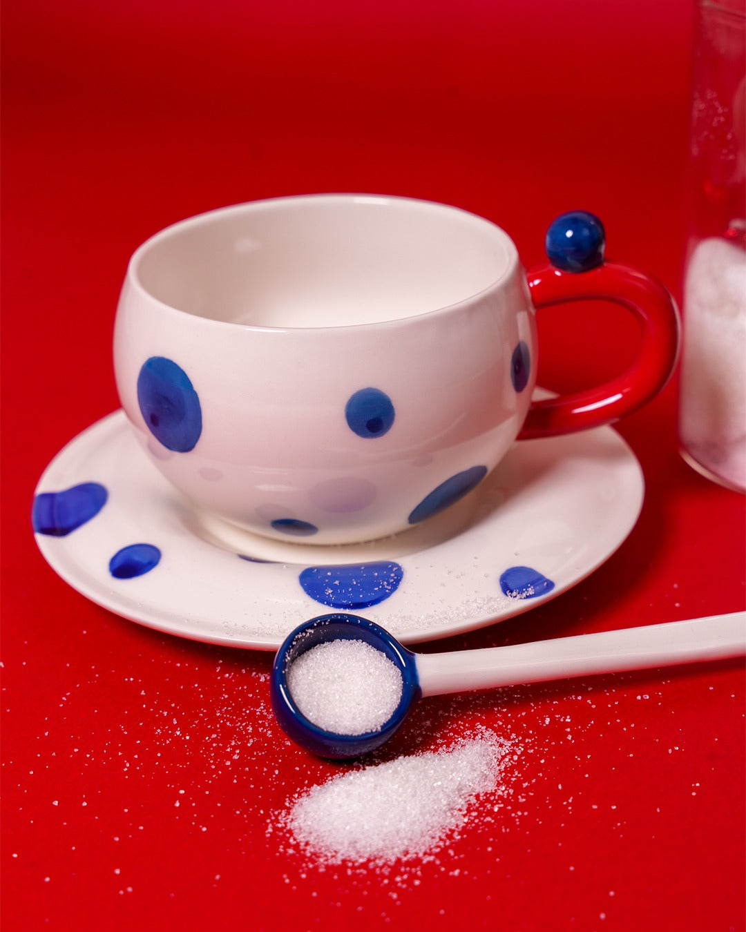 White mug with navy blue dots with spoon